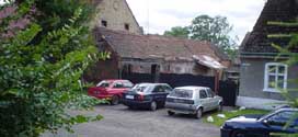Cars by old house and barn